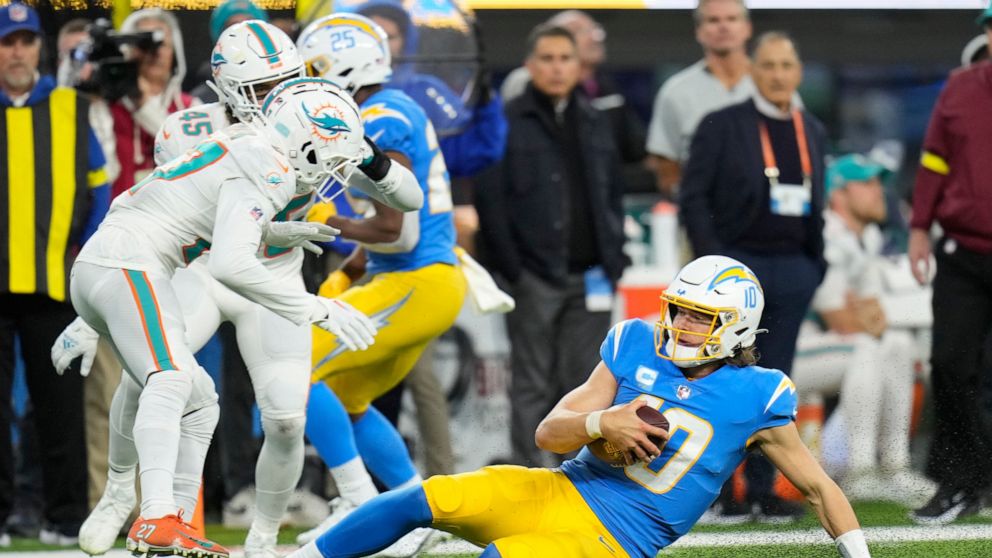 Los Angeles Chargers quarterback Justin Herbert slides for a first down during the second half of an NFL football game against the Miami Dolphins Sunday, Dec. 11, 2022, in Inglewood, Calif. (AP Photo/Jae C. Hong)