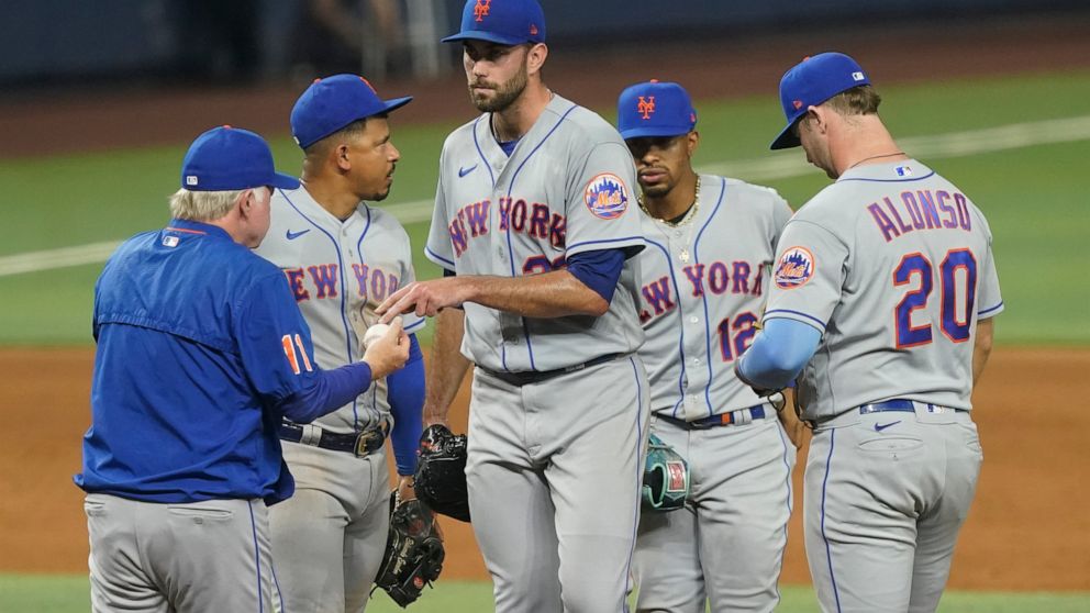 New York Mets starting pitcher David Peterson (23) hands the ball to manager Buck Showalter during the fourth inning of a baseball game against the Miami Marlins, Friday, Sept. 9, 2022, in Miami. (AP Photo/Marta Lavandier)