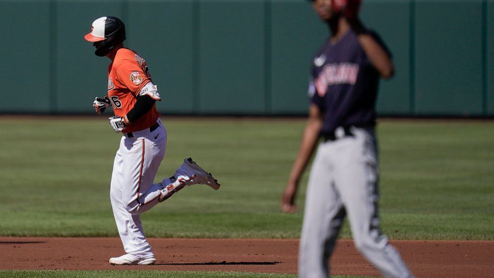 Baltimore Orioles' Trey Mancini, left, runs the bases as Cleveland Guardians starting pitcher Triston McKenzie, right, waits for a new ball after Mancini hit a solo home run off him during the first inning of a baseball game, Saturday, June 4, 2022, 