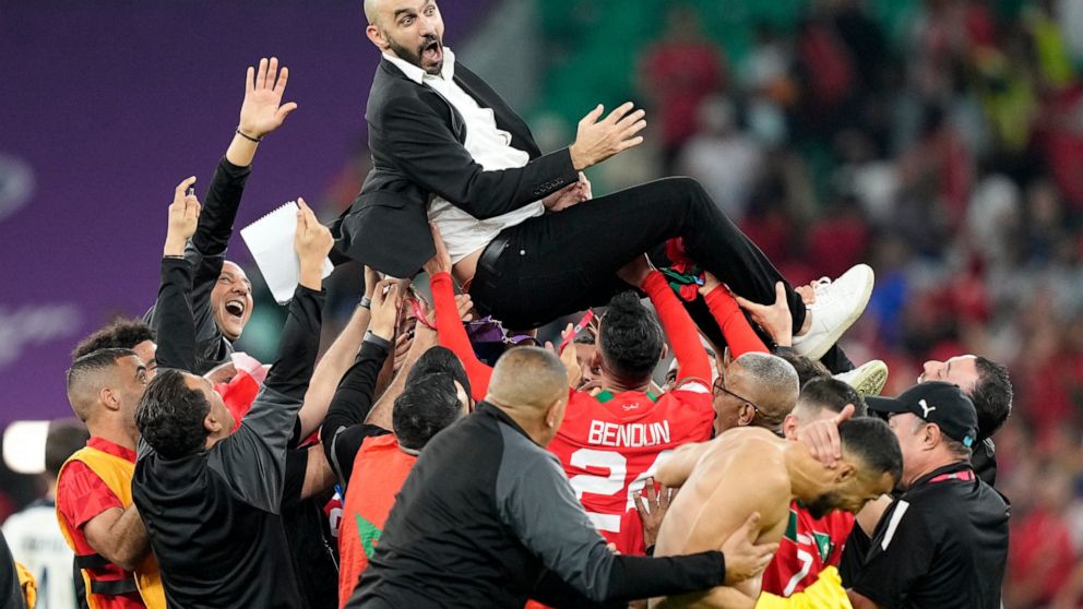 Morocco's head coach Walid Regragui is thrown in the air by players after the World Cup quarterfinal soccer match between Morocco and Portugal, at Al Thumama Stadium in Doha, Qatar, Saturday, Dec. 10, 2022. (AP Photo/Martin Meissner)
