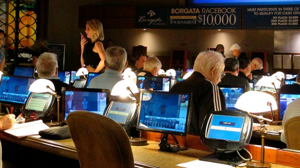 FILE - This June 14, 2018 file photo shows bettors waiting to make wagers on sporting events at the Borgata casino in Atlantic City hours after it began accepting sports bets. It's hard enough for compulsive gamblers to stop betting. Now, in a growin
