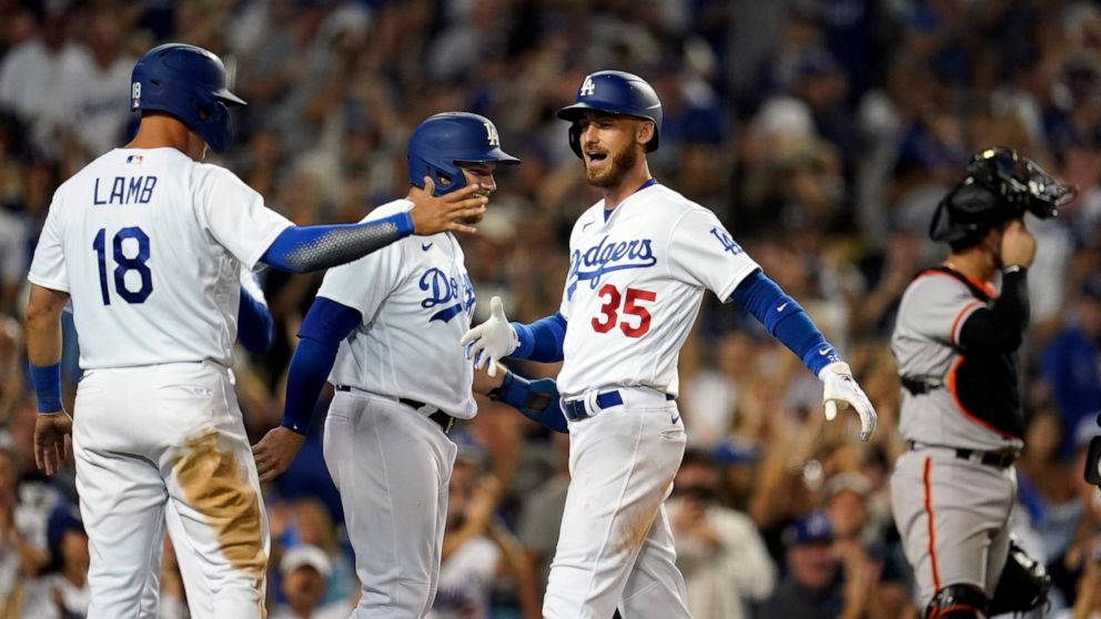 Los Angeles Dodgers' Cody Bellinger (35) celebrates his grand slam at home plate with Max Muncy and Jake Lamb (18) during the eighth inning of the team's baseball game against the San Francisco Giants on Friday, July 22, 2022, in Los Angeles. (AP Pho