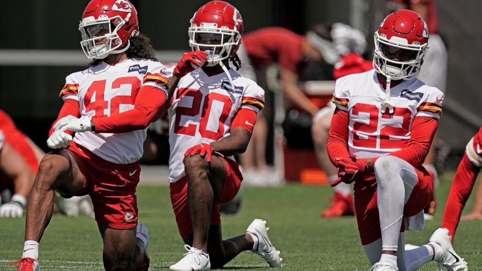 Kansas City Chiefs defensive back Devon Key (42), safety Justin Reid (20) and safety Juan Thornhill (22) stretch during the NFL football team's organized team activities Thursday, June 9, 2022, in Kansas City, Mo. (AP Photo/Charlie Riedel)