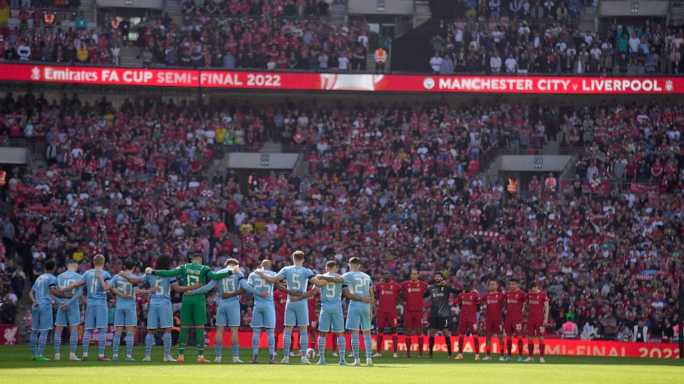 Manchester City, left, and Liverpool players stand for a moment of silence to remember those who died in the 1989 Hillsborough disaster, before the English FA Cup semifinal soccer match between Manchester City and Liverpool at Wembley stadium in Lond