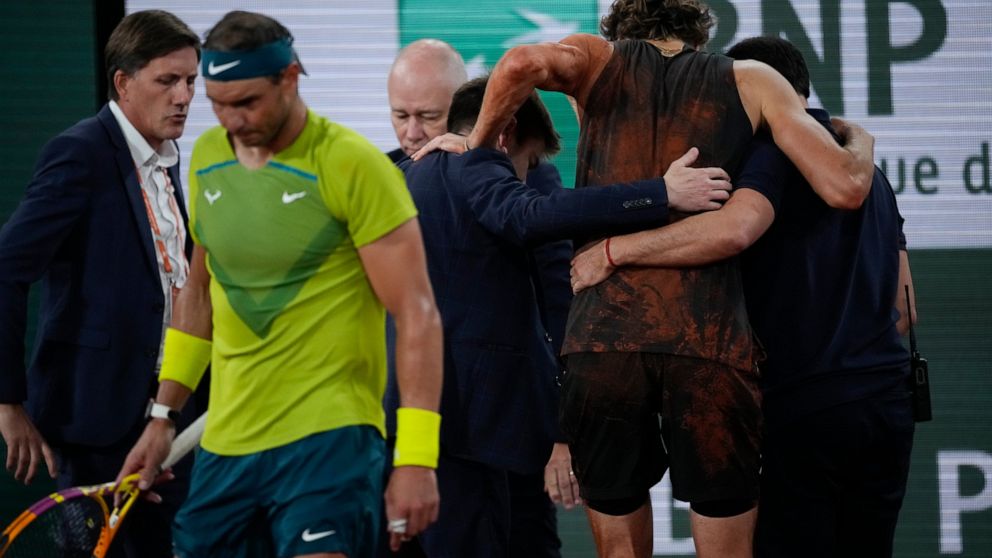 Germany's Alexander Zverev is carried off the court after twisting his ankle during the semifinal match against Spain's Rafael Nadal, left, at the French Open tennis tournament in Roland Garros stadium in Paris, France, Friday, June 3, 2022. (AP Phot