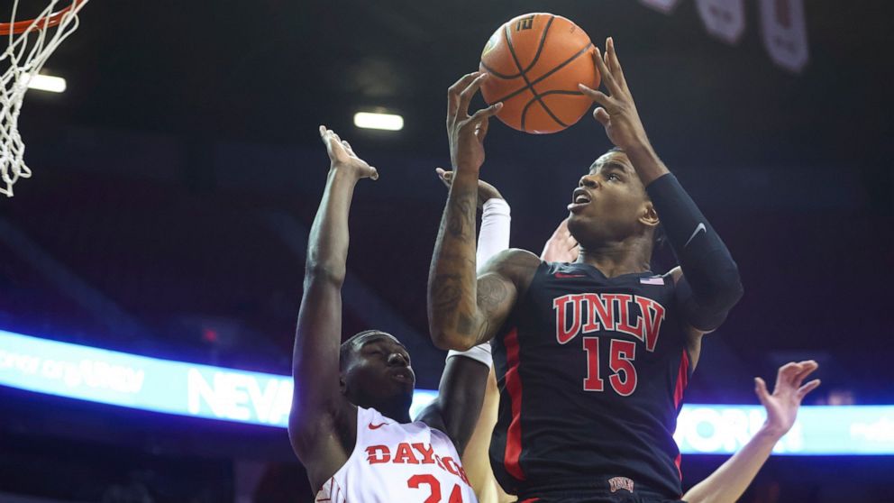 UNLV guard Luis Rodriguez (15) lays up as Dayton's Kobe Elvis (24) guards during the first half of an NCAA college basketball game Tuesday, Nov. 15, 2022, in Las Vegas. (AP Photo/Chase Stevens)