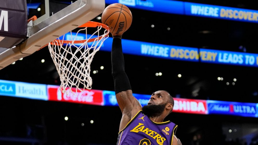 Los Angeles Lakers forward LeBron James (6) dunks during the first half of an NBA basketball game against the Denver Nuggets in Los Angeles, Friday, Dec. 16, 2022. (AP Photo/Ashley Landis)