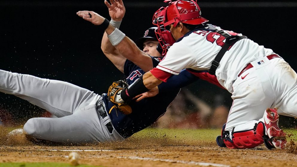 Boston Red Sox's Bobby Dalbec, left, is out at home after a tag from Los Angeles Angels catcher Kurt Suzuki (24) during the sixth inning of a baseball game in Anaheim, Calif., Wednesday, June 8, 2022. (AP Photo/Ashley Landis)