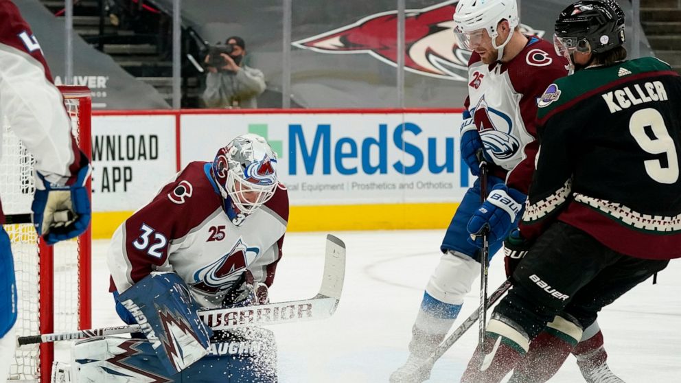 Colorado Avalanche goaltender Hunter Miska (32) makes a save as Arizona Coyotes right wing Clayton Keller (9) and Avalanche defenseman Devon Toews, second from right, look on during the first period of an NHL hockey game Friday, Feb. 26, 2021, in Gle