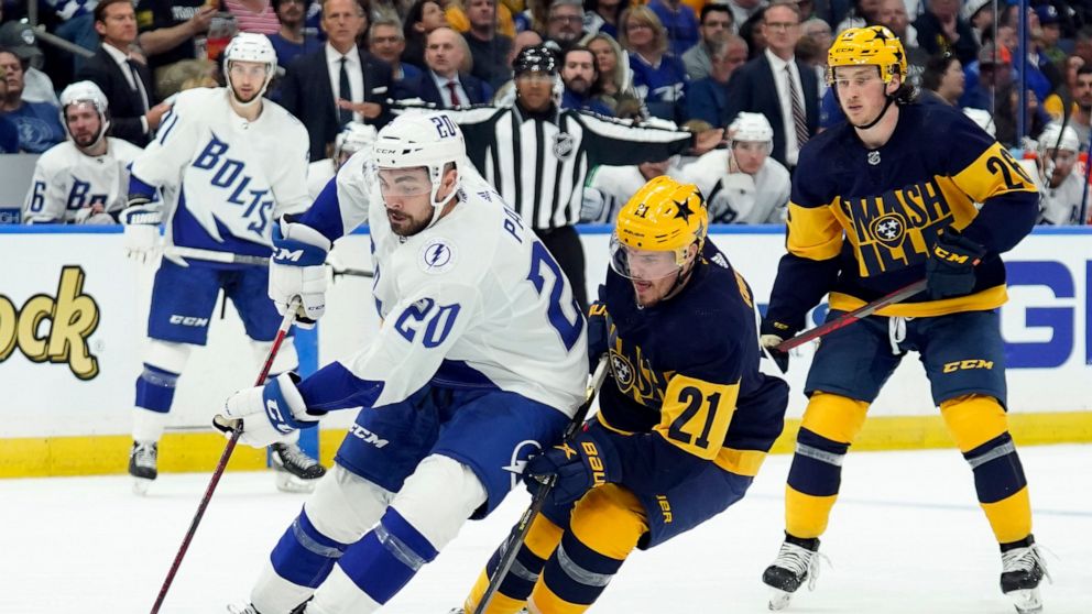Tampa Bay Lightning left wing Nicholas Paul (20) gets around Nashville Predators center Nick Cousins (21) during the second period of an NHL hockey game Saturday, April 23, 2022, in Tampa, Fla. (AP Photo/Chris O'Meara)