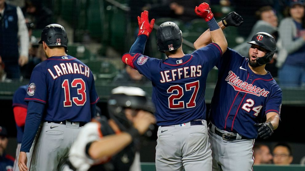 Minnesota Twins' Ryan Jeffers (27) is greeted near home plate by Gary Sanchez (24) after Jeffers scored Sanchez, Trevor Larnach (13) and himself on three-run home run against the Baltimore Orioles during the sixth inning of a baseball game, Tuesday, 