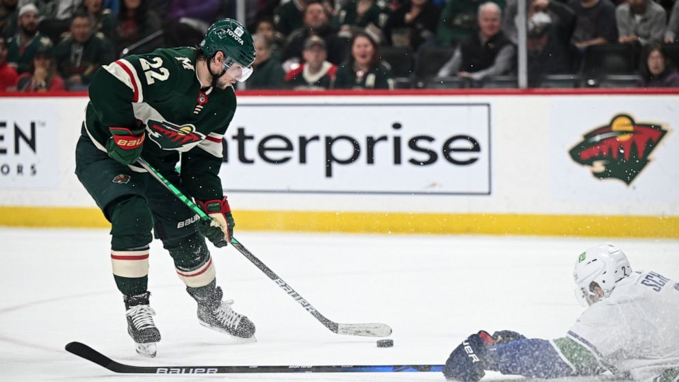 Vancouver Canucks defenseman Luke Schenn (2) slides to the ice to try to block a shot by Minnesota Wild left wing Kevin Fiala (22) during the first period of an NHL hockey game Thursday, April 21, 2022, in St. Paul, Minn. (Aaron Lavinsky/Star Tribune