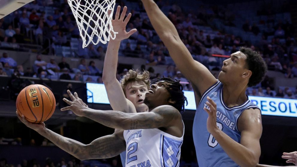 North Carolina guard Caleb Love (2) drives in against Citadel forwards Stephen Clark (1) and forward Jackson Price (0) during the first half of an NCAA college basketball game Tuesday, Dec. 13, 2022, in Chapel Hill, N.C. (AP Photo/Chris Seward)