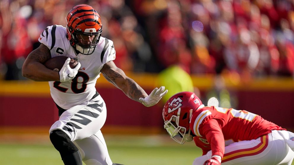 Cincinnati Bengals running back Joe Mixon (28) evades a tackle attempt by Kansas City Chiefs safety Juan Thornhill (22) during the first half of the AFC championship NFL football game, Sunday, Jan. 30, 2022, in Kansas City, Mo. (AP Photo/Charlie Riedel)