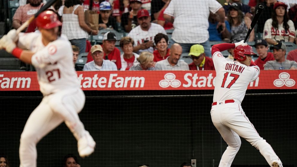 Los Angeles Angels' Shohei Ohtani, right, of Japan, prepares for his at-bat as Mike Trout stands in the batter's box during the third inning of a baseball game against the Houston Astros Tuesday, July 12, 2022, in Anaheim, Calif. (AP Photo/Jae C. Hong)