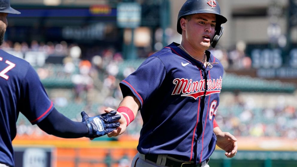 Minnesota Twins first baseman Jose Miranda is greeted by teammate Gary Sanchez after scoring during the seventh inning of a baseball game against the Detroit Tigers, Sunday, July 24, 2022, in Detroit. (AP Photo/Carlos Osorio)