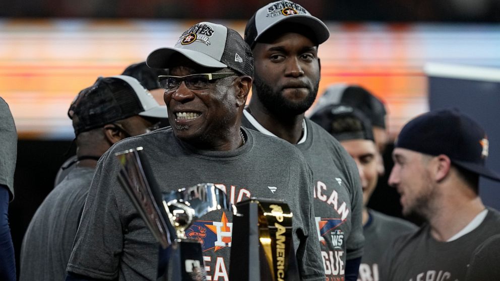 Houston Astros manager Dusty Baker Jr. stands by the trophy after their win against the Boston Red Sox in Game 6 of baseball's American League Championship Series Friday, Oct. 22, 2021, in Houston. The Astros won 5-0, to win the ALCS series in game s