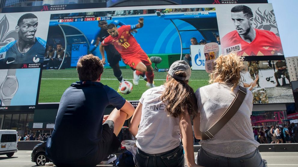 FILE - French soccer fans watch France play Belgium in a World Cup semifinal soccer game on a gigantic screen in New York's Times Square, on July 10, 2018, in New York. U.S. cities and states have lined up with tax breaks and millions of dollars in b