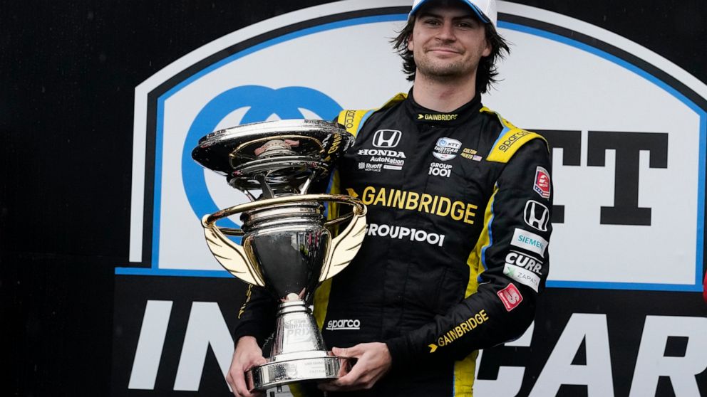 Colton Herta holds the trophy after winning an IndyCar auto race at Indianapolis Motor Speedway, Saturday, May 14, 2022, in Indianapolis. (AP Photo/Darron Cummings)