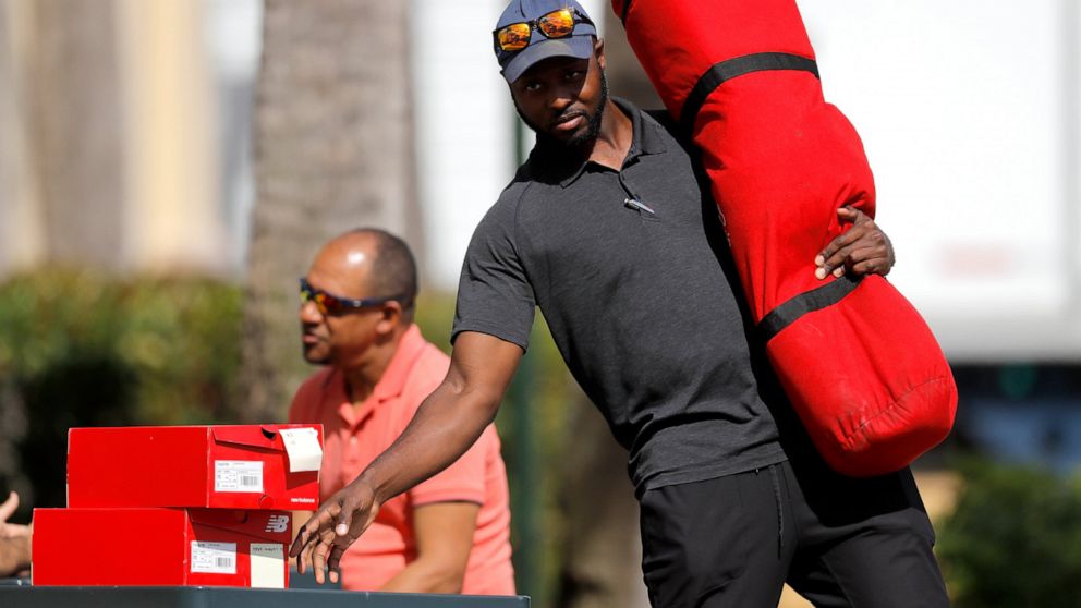 St. Louis Cardinals minor league outfielder Bradley Roper-Hubbert carries gear as he leaves the team's spring training baseball clubhouse, Friday, March 13, 2020, in Jupiter, Fla. Major League Baseball has delayed the start of its season by at least 