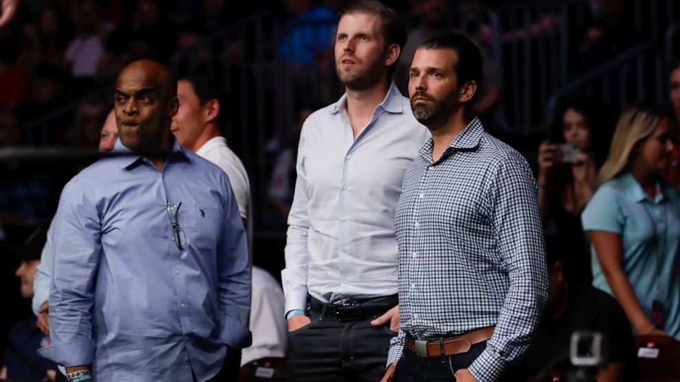 Donald Trump Jr., right, and Eric Trump, center, watch the post fight ceremony of a lightweight mixed martial arts bout between Jim Miller and Clay Guida at UFC Fight Night Saturday, Aug. 3, 2019, in Newark, N.J. Guida stopped Miller in the first rou