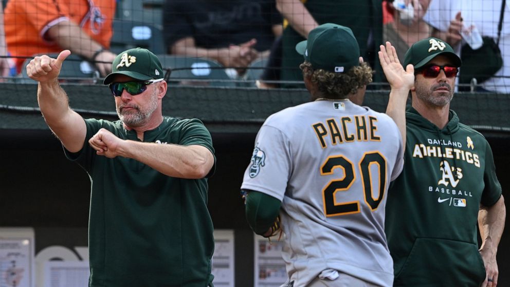 Oakland Athletics manager Mark Kotsay, left, gives a thumbs-up after defeating the Baltimore Orioles in a baseball game, Sunday, Sept. 4, 2022, in Baltimore. (AP Photo/Gail Burton)