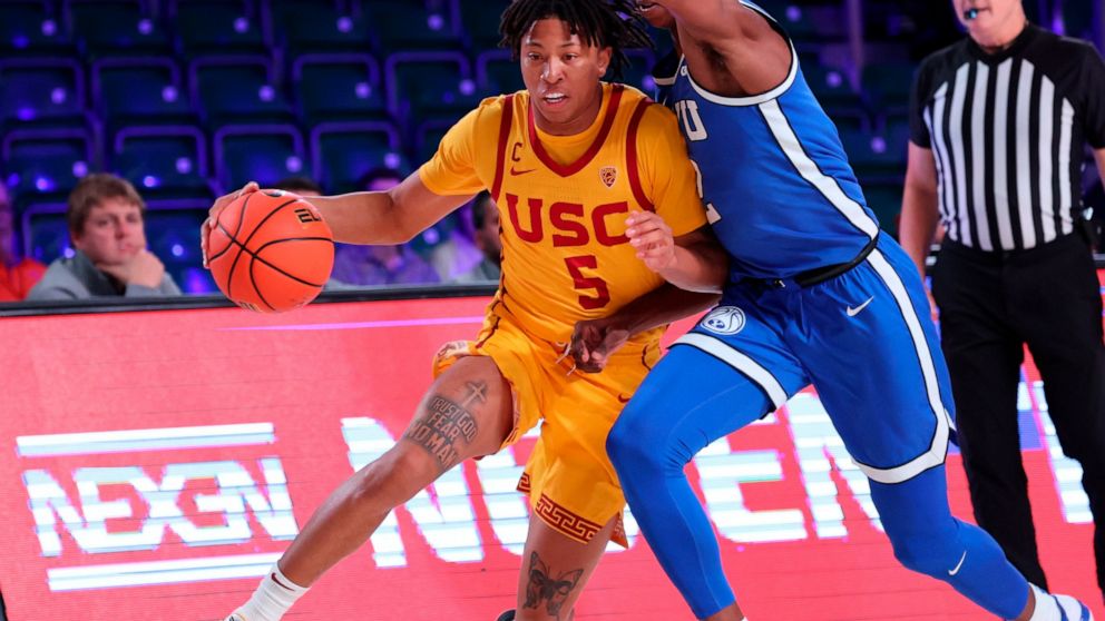 In a photo provided by Bahamas Visual Services, Southern California's Boogie Ellis drives against BYU's Jaxson Robinson during an NCAA college basketball game in the Battle 4 Atlantis at Paradise Island, Bahamas, Wednesday, Nov. 23, 2022. (Tim Aylen/