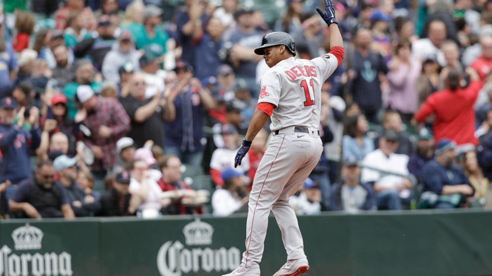 Boston Red Sox's Rafael Devers celebrates as he runs home after hitting a two-run home run on a pitch from Seattle Mariners' Paul Sewald during the eighth inning of a baseball game, Sunday, June 12, 2022, in Seattle. (AP Photo/John Froschauer)