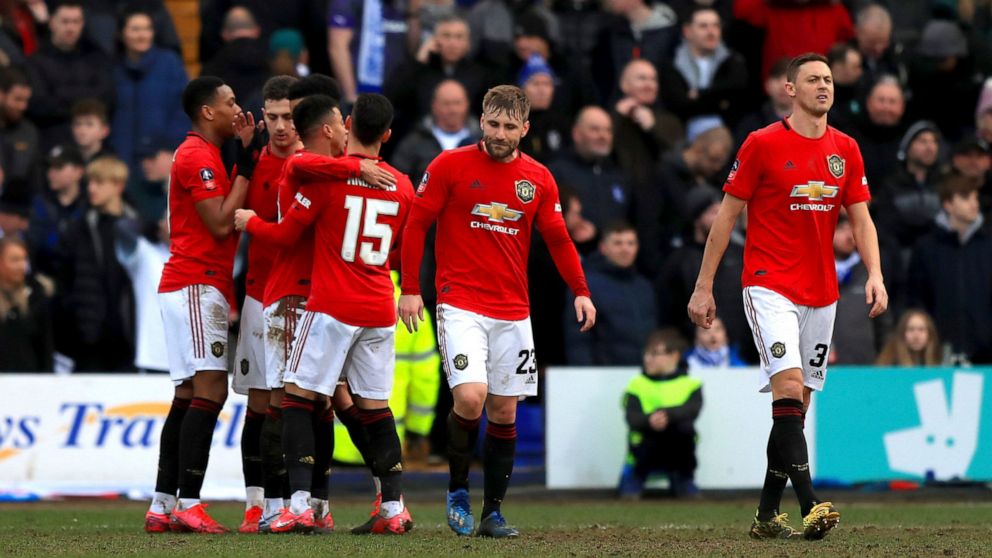 Manchester United's Anthony Martial, left, celebrates scoring his side's fifth goal of the game against Tranmere, with teammates during their English FA Cup fourth round soccer match at Prenton Park in Birkenhead, England, Sunday Jan. 26, 2020. (Simo