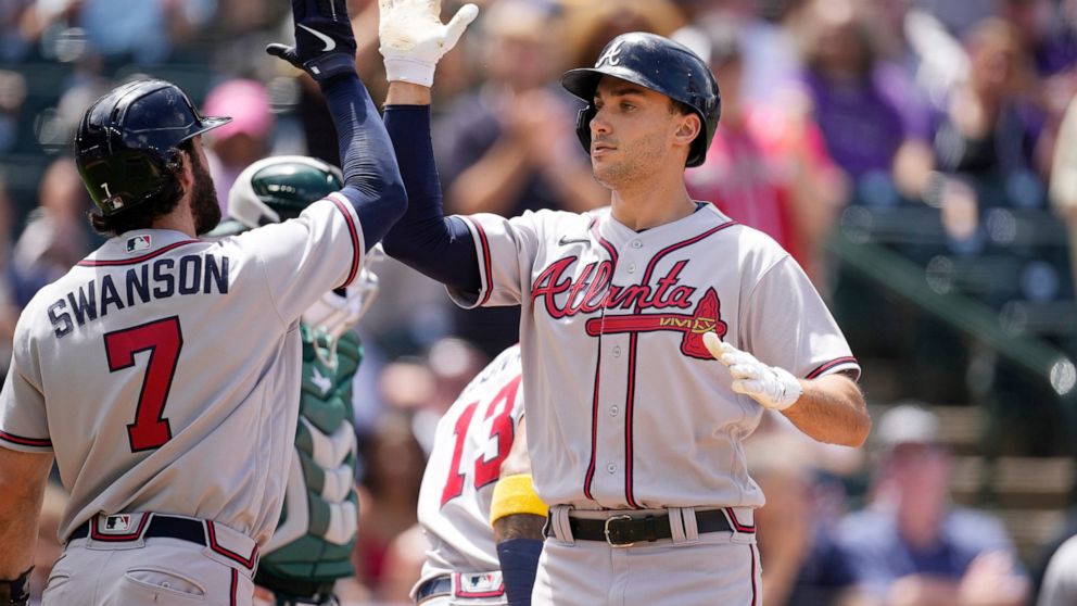 Atlanta Braves' Dansby Swanson, left, congratulates Matt Olson who crosses home plate after hitting a three-run home run off Colorado Rockies starting pitcher Ryan Feltner in the second inning of a baseball game Sunday, June 5, 2022, in Denver. (AP P