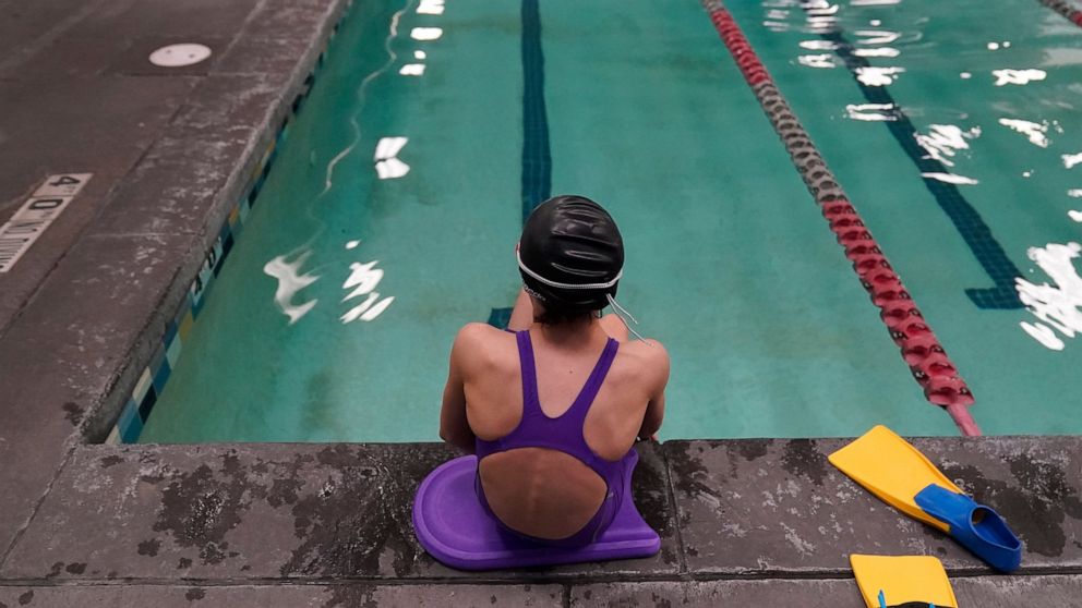 FILE - A 12-year-old transgender swimmer waits by a pool on Feb. 22, 2021, in Utah. Transgender kids in Utah will be not be subjected to sports participation limits at the start of the upcoming school year after a judge delayed the implementation of 