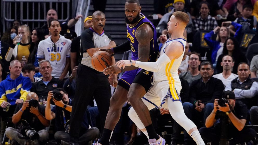 Golden State Warriors guard Donte DiVincenzo, right, defends against Los Angeles Lakers forward LeBron James, left, during the first half of an NBA basketball game in San Francisco, Tuesday, Oct. 18, 2022. (AP Photo/Godofredo A. Vásquez)
