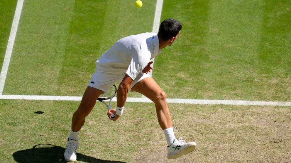 Serbia's Novak Djokovic returns to Britain's Cameron Norrie in a men's singles semifinal on day twelve of the Wimbledon tennis championships in London, Friday, July 8, 2022. (AP Photo/Kirsty Wigglesworth)