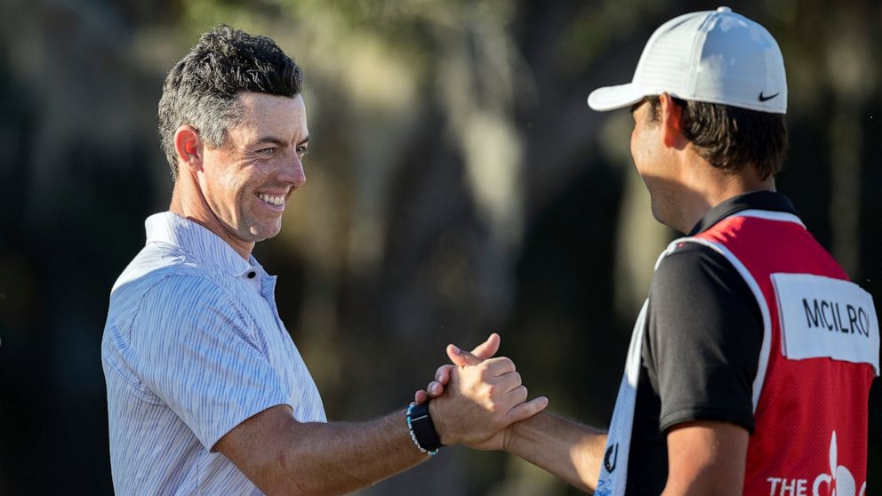 Rory McIlroy, left, of Northern Ireland, left, celebrates with his caddie after the final round of the CJ Cup golf tournament Sunday, Oct. 23, 2022, in Ridgeland, S.C. (AP Photo/Stephen B. Morton)