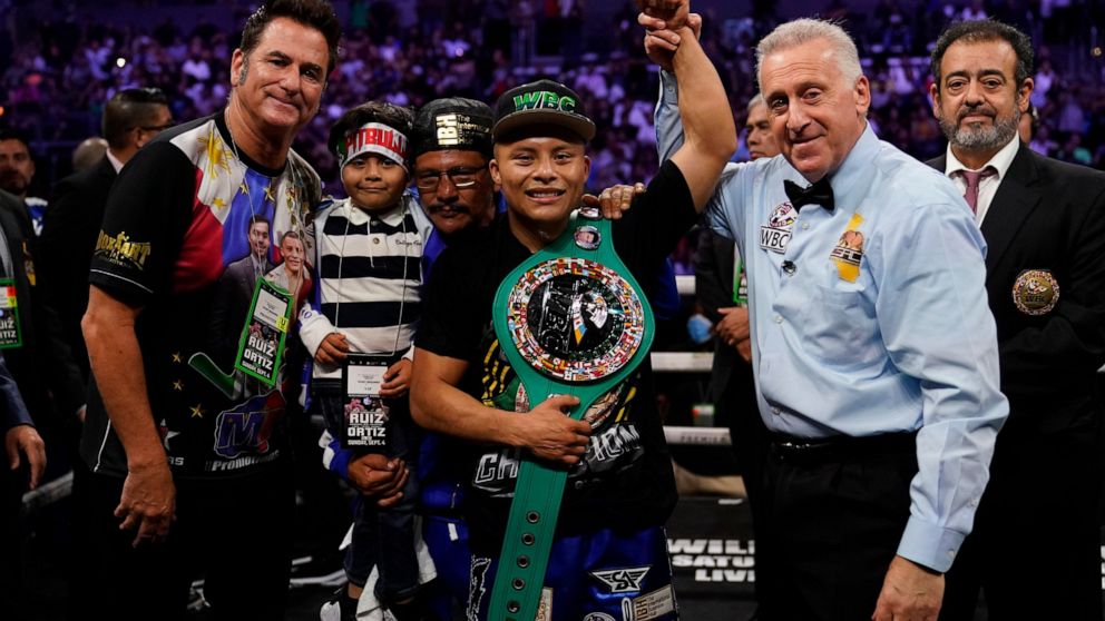 Isaac Cruz, center, celebrates after winning a WBC world lightweight title eliminator boxing match against Eduardo Ramirez, Sunday, Sept. 4, 2022, in Los Angeles. (AP Photo/Ashley Landis)