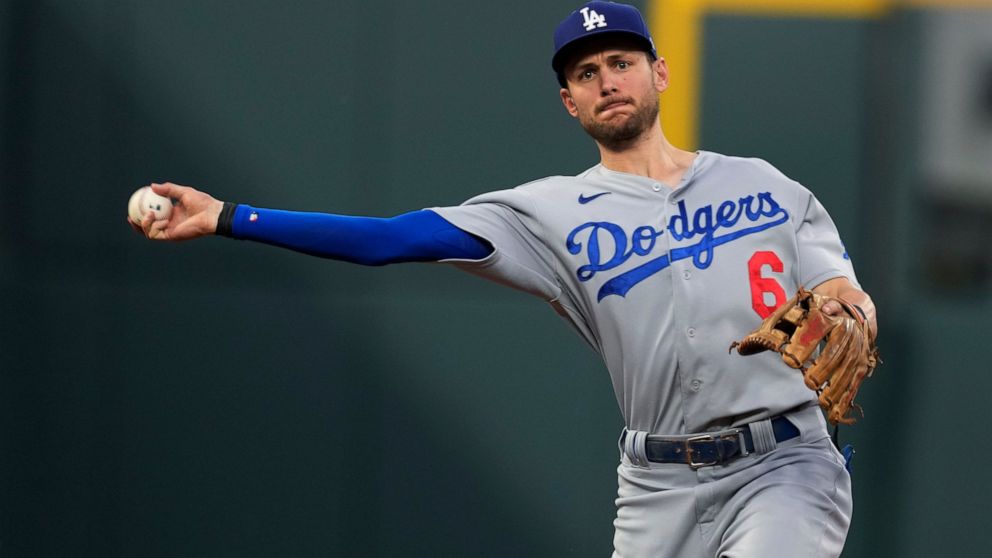 Los Angeles Dodgers shortstop Trea Turner thorws to first base to put out Colorado Rockies' Yonathan Daza during the third inning of a baseball game Wednesday, June 29, 2022, in Denver. (AP Photo/David Zalubowski)