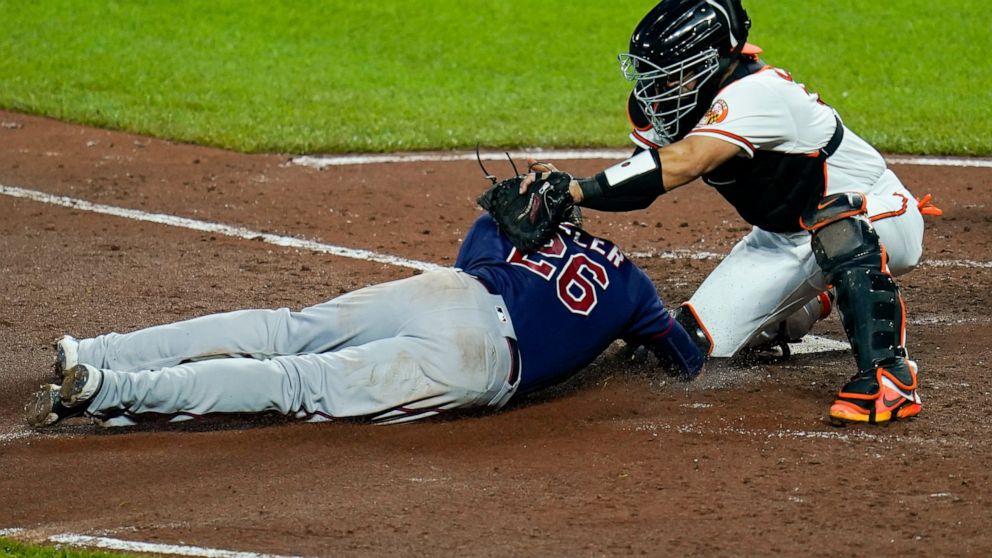 Baltimore Orioles catcher Robinson Chirinos, right, tags out Minnesota Twins' Max Kepler trying to score on a double by Gary Sanchez during the fourth inning of a baseball game, Thursday, May 5, 2022, in Baltimore. (AP Photo/Julio Cortez)