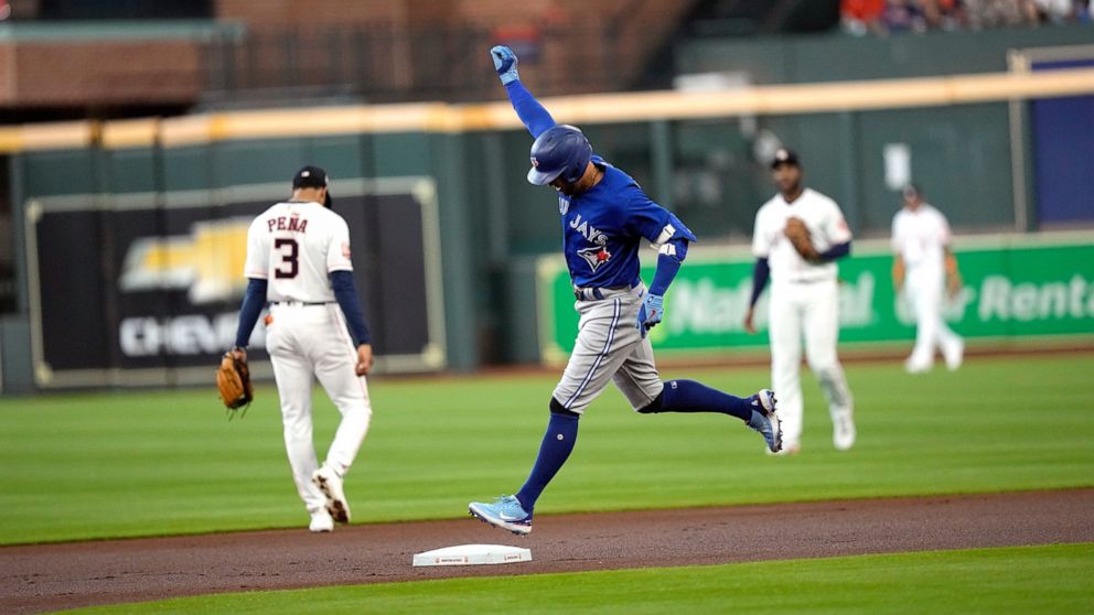 Toronto Blue Jays' George Springer celebrates as he runs the bases after hitting a home run against the Houston Astros during the first inning of a baseball game Saturday, April 23, 2022, in Houston. (AP Photo/David J. Phillip)