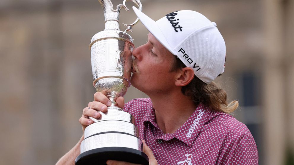 Cameron Smith, of Australia, kisses the claret jug trophy as he poses for photographers on the 18th green after winning the British Open golf Championship on the Old Course at St. Andrews, Scotland, Sunday July 17, 2022. (AP Photo/Peter Morrison)