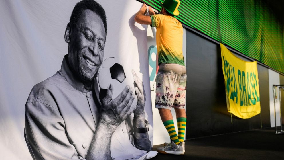 A fan displays a sign in support of Pelé at a Brazilian fan party before the the World Cup round of 16 soccer match between Brazil and South Korea, in Doha, Dec. 5, 2022. The 82-year-old Pelé remained in a hospital in San Paulo recovering from a resp