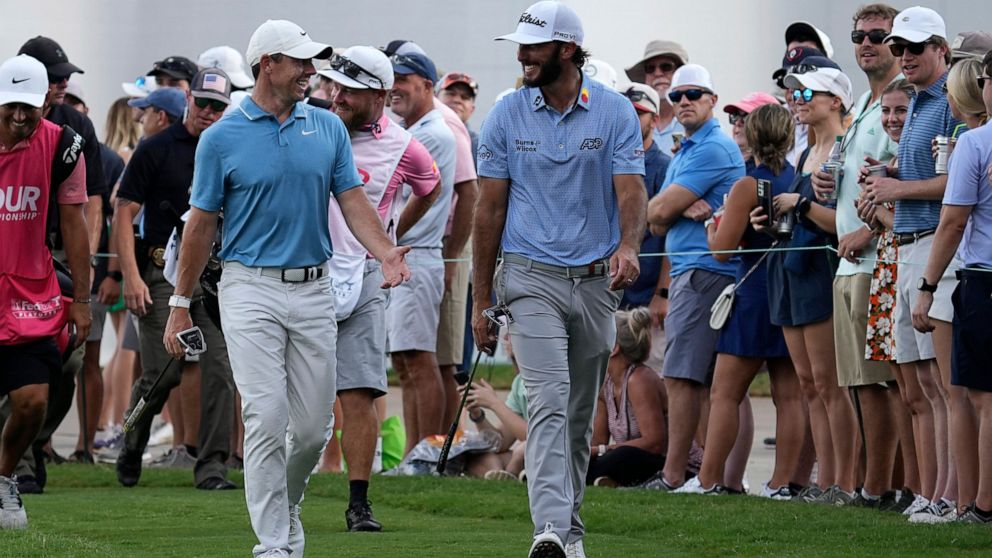 Rory McIlroy, of Northern Ireland,, left, and Max Homa, right, walk to the 15th green during the third round of the Tour Championship golf tournament at East Lake Golf Club Saturday, Aug. 27, 2022, in Atlanta. (AP Photo/Steve Helber)