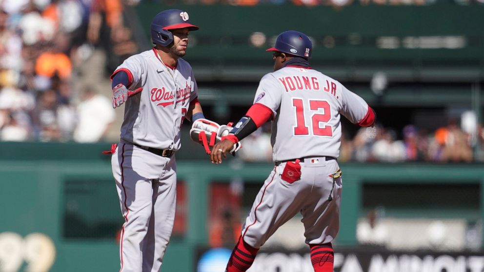 Washington Nationals' Yadiel Hernandez, left, is congratulated by first base coach Eric Young Jr. (12) after hitting a three-run double against the San Francisco Giants during the eighth inning of a baseball game in San Francisco, Sunday, May 1, 2022