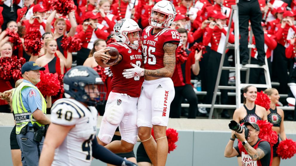North Carolina State's Anthony Smith (85) congratulates Jordan Houston (3) on his touchdown during the first half of an NCAA college football game against the Charleston Southern in Raleigh, N.C., Saturday, Sept. 10, 2022. (AP Photo/Karl B DeBlaker)
