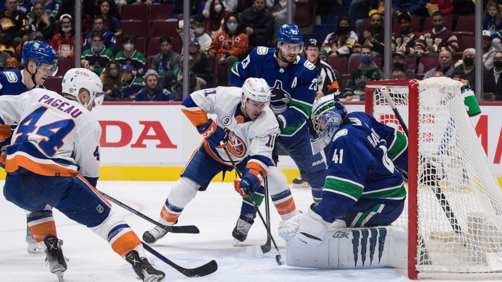 New York Islanders' Zach Parise (11) scores against Vancouver Canucks goalie Jaroslav Halak (41) as Canucks' Oliver Ekman-Larsson (23) watches during the first period of an NHL hockey game Wednesday, Feb. 9, 2022, in Vancouver, British Columbia. (Dar