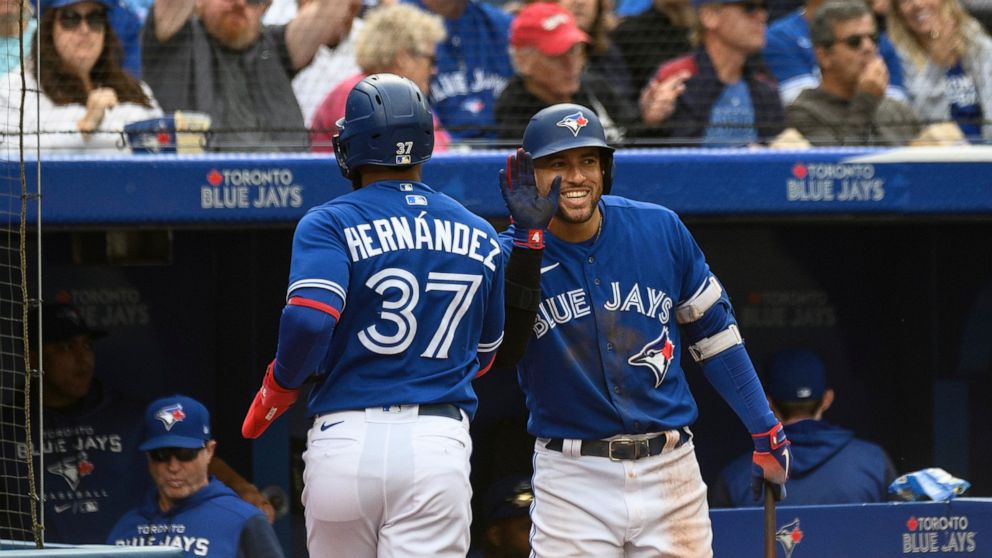 Toronto Blue Jays outfielder Teoscar Hernandez (37) celebrates with teammate George Springer after scoring on a single by catcher Danny Jensen during the second inning of a baseball game against the Boston Red Sox in Toronto on Saturday, Oct. 1, 2022