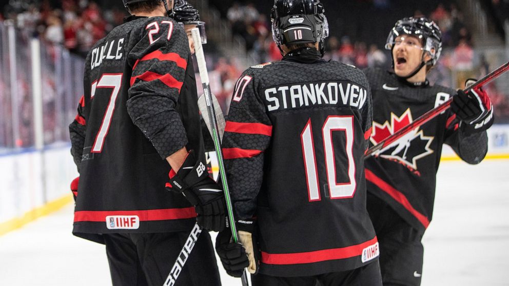 Canada's Will Cuylle (27), Logan Stankoven (10) and Donovan Sebrango celebrate a goal against Switzerland during the second period in a quarterfinal in the IIHF junior world hockey championships Wednesday, Aug. 17, 2022, in Edmonton, Alberta. (Jason 