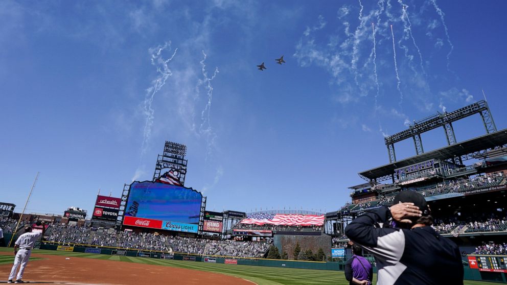 Two F-16 jets from Buckley Air Force Base in Aurora, Colo., fly over Coors Field before a baseball game between the Los Angeles Dodgers and the Colorado Rockies on opening day, Thursday, April 1, 2021, in Denver. The Rockies won 8-5. (AP Photo/David 
