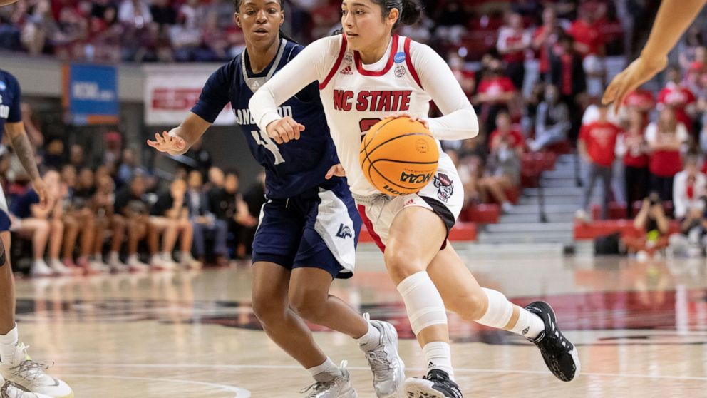 North Carolina State's Raina Perez, right, drives past Longwood's Kennedy Calhoun (4) during the second half of a college basketball game in the first round of the NCAA tournament in Raleigh, N.C., Saturday, March 19, 2022. (AP Photo/Ben McKeown)