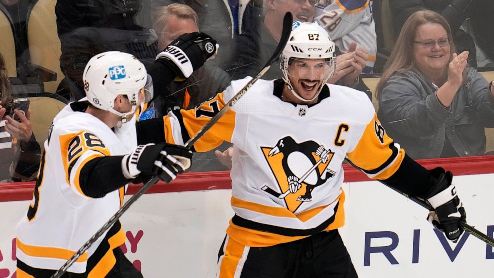 Pittsburgh Penguins' Sidney Crosby (87) celebrates his goal against the Buffalo Sabres with Marcus Pettersson during the third period of an NHL hockey game in Pittsburgh, Saturday, Dec. 10, 2022. (AP Photo/Gene J. Puskar)