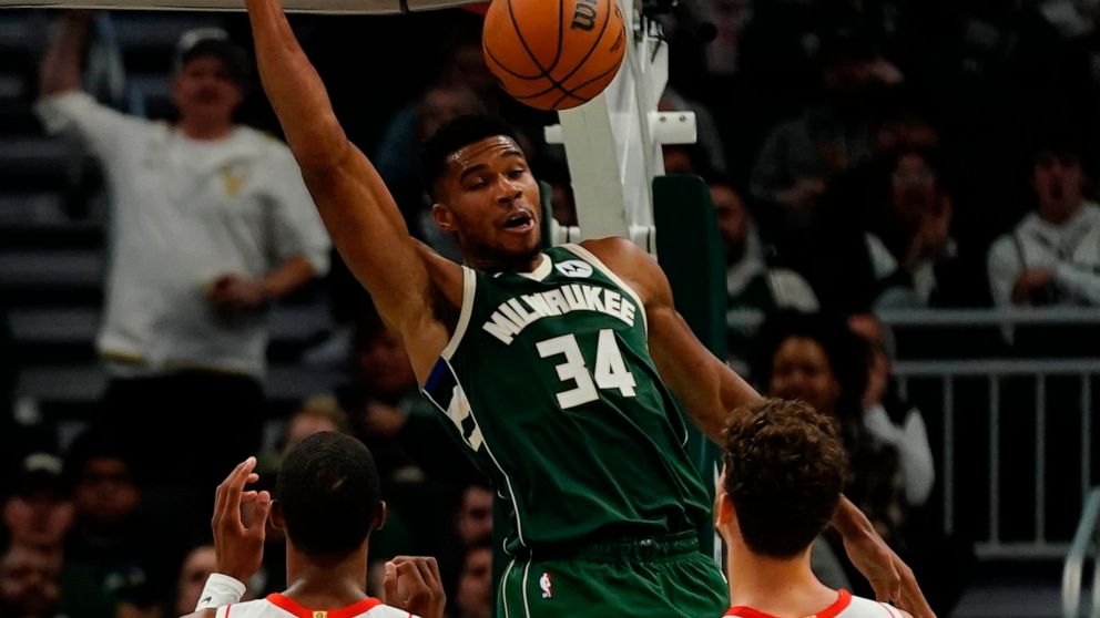 Milwaukee Bucks' Giannis Antetokounmpo dunks over Houston Rockets' Jabari Smith Jr. and Alperen Sengun during the first half of an NBA basketball game Saturday, Oct. 22, 2022, in Milwaukee. (AP Photo/Morry Gash)